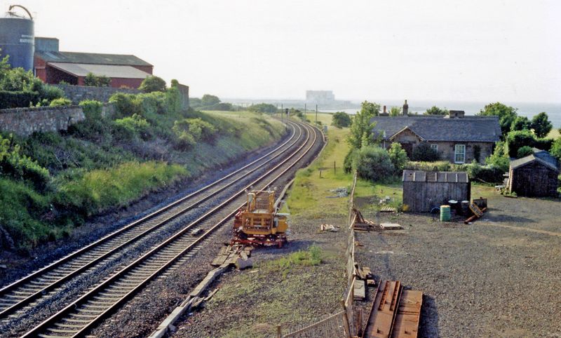 An archival 1988 view over the railway tracks at the former Cockburnspath station, with the station house and North Sea beyond.